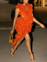 Woman in an orange ruffled mini dress and yellow handbag walking