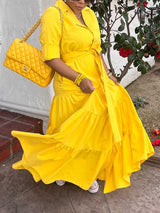 Woman twirling in a yellow tiered maxi dress, showing the movement of the skirt.