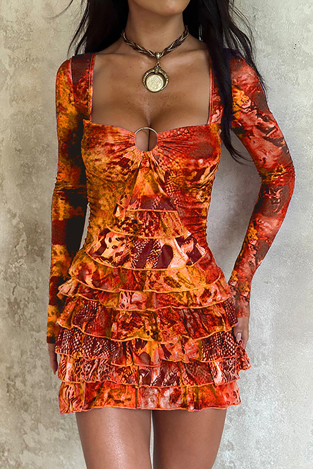 woman wearing an orange long-sleeved mini dress with a square neckline and ruffled hem
