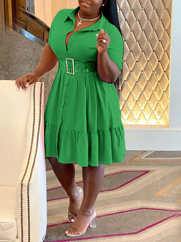 Woman wearing a green dress with a belted waist, accentuating the fit-and-flare silhouette.