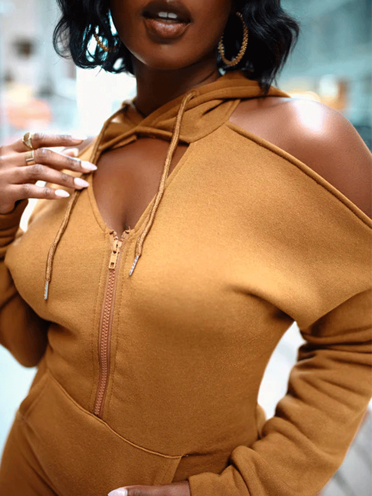 full body shot of a woman wearing a brown hooded dress and black boots