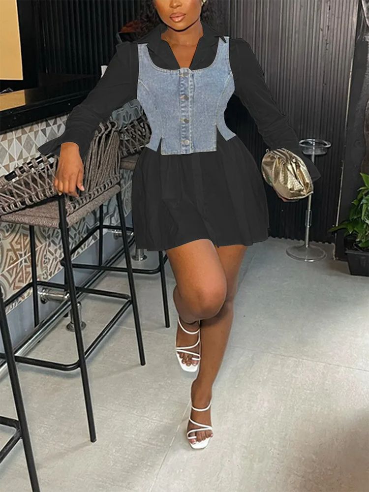 Woman in a black collared shirt dress with a denim vest overlay and white sandals