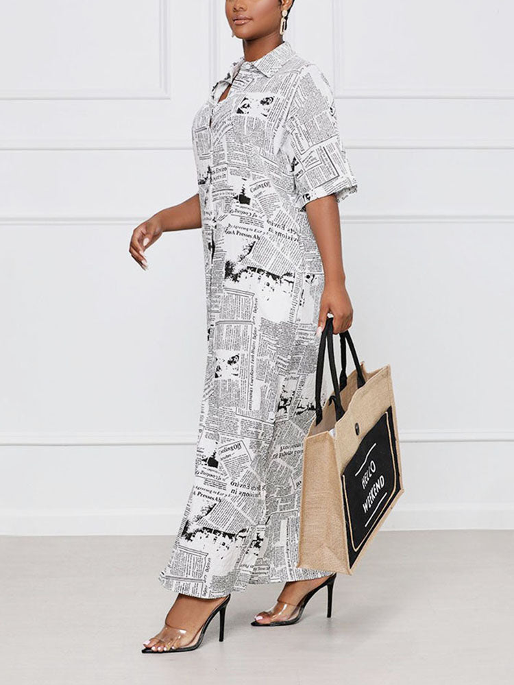 Woman walking to the side wearing a white and black newspaper print maxi dress and holding a canvas tote bag.