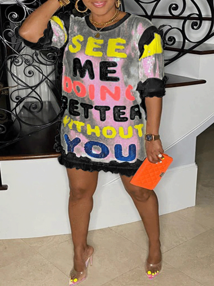 Woman in a black and white sequined t-shirt dress with colorful text and ruffled hem, holding an orange clutch.