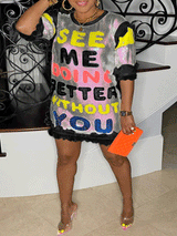 Woman in a black and white sequined t-shirt dress with colorful text and ruffled hem, holding an orange clutch.