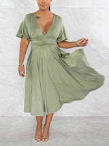 Woman twirling in a light green midi dress, showing the flowy skirt