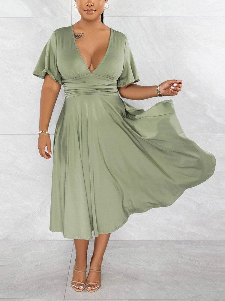 Woman twirling in a light green midi dress, showing the flowy skirt