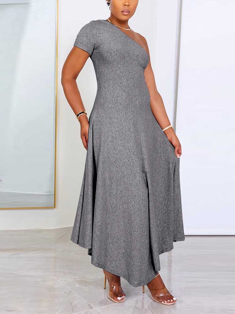 Side view of a woman in a grey one-shoulder midi dress, showcasing the flowing skirt.