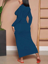 Rear view of a woman wearing a teal ruched maxi dress with long sleeves.