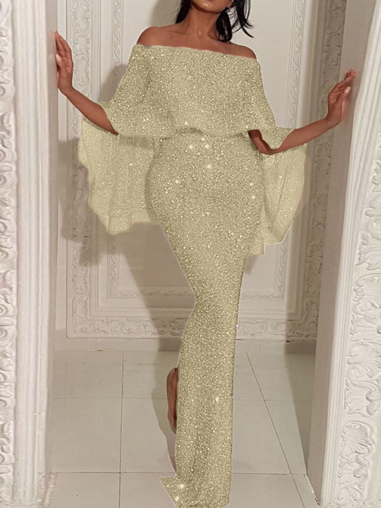 Woman wearing a gold glitter off-the-shoulder maxi dress with cape sleeves