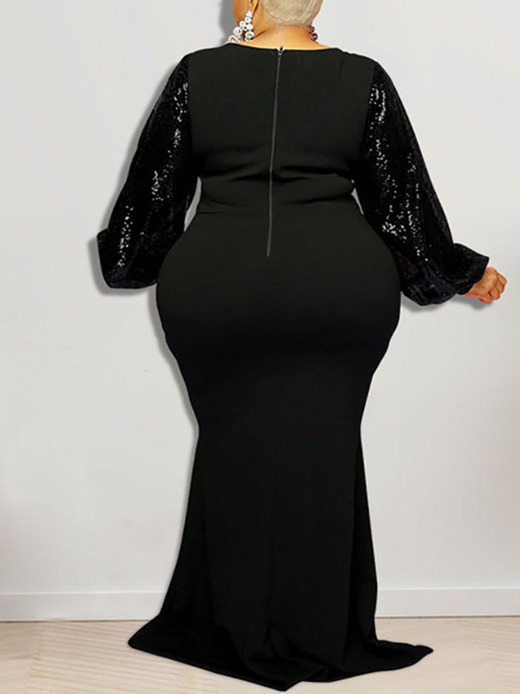 Back view of a woman in a black mermaid silhouette dress featuring sequined sleeves.