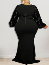 Back view of a woman in a black mermaid silhouette dress featuring sequined sleeves.