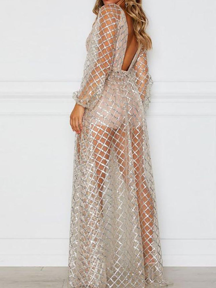 Rear view of a woman in a long, sheer, sparkling gold dress with long sleeves and a low back, indoors.
