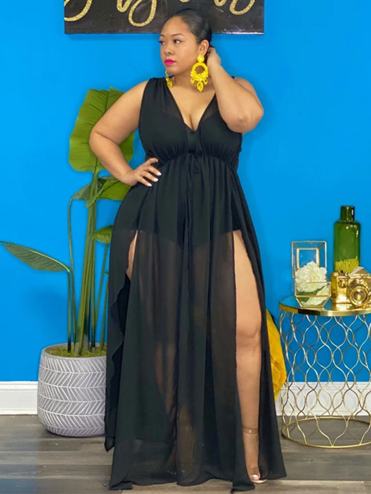 Woman wearing a black sheer maxi dress with high leg slits, front view