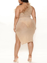 Back view of a woman wearing a nude one-shoulder midi dress with feather trim and rhinestone and pearl embellishments.