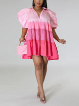 Full body shot of a woman in a pink tiered mini dress with puff sleeves