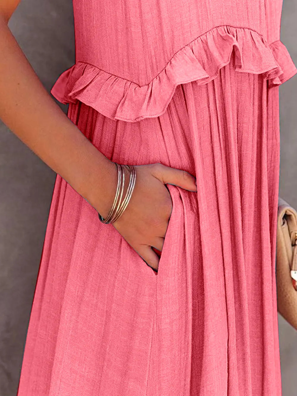 close-up of a woman's hand in the pocket of a pink tiered ruffle maxi dress