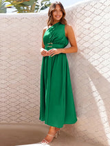 Woman in a green one-shoulder midi dress with a belted waist, posing outdoors.