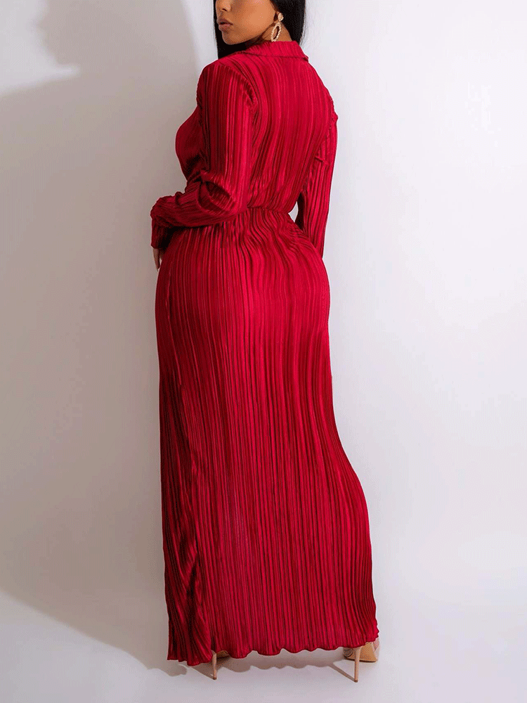Woman wearing a black pleated maxi dress with a high slit and deep V-neck.