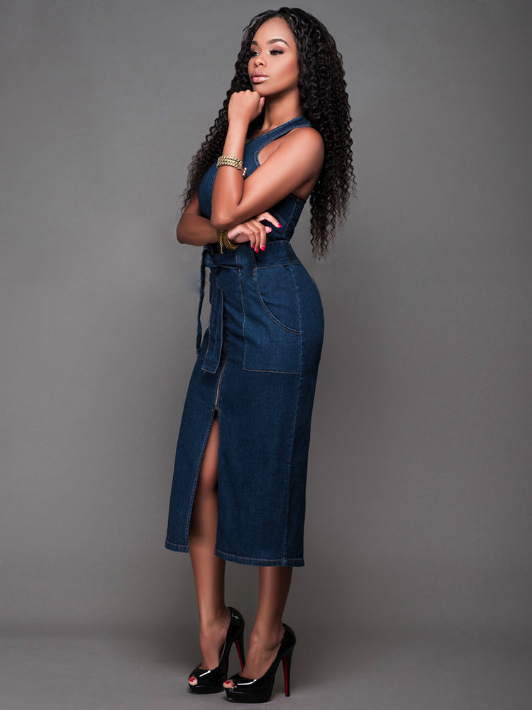 side view of a woman in a denim sheath dress with a front slit