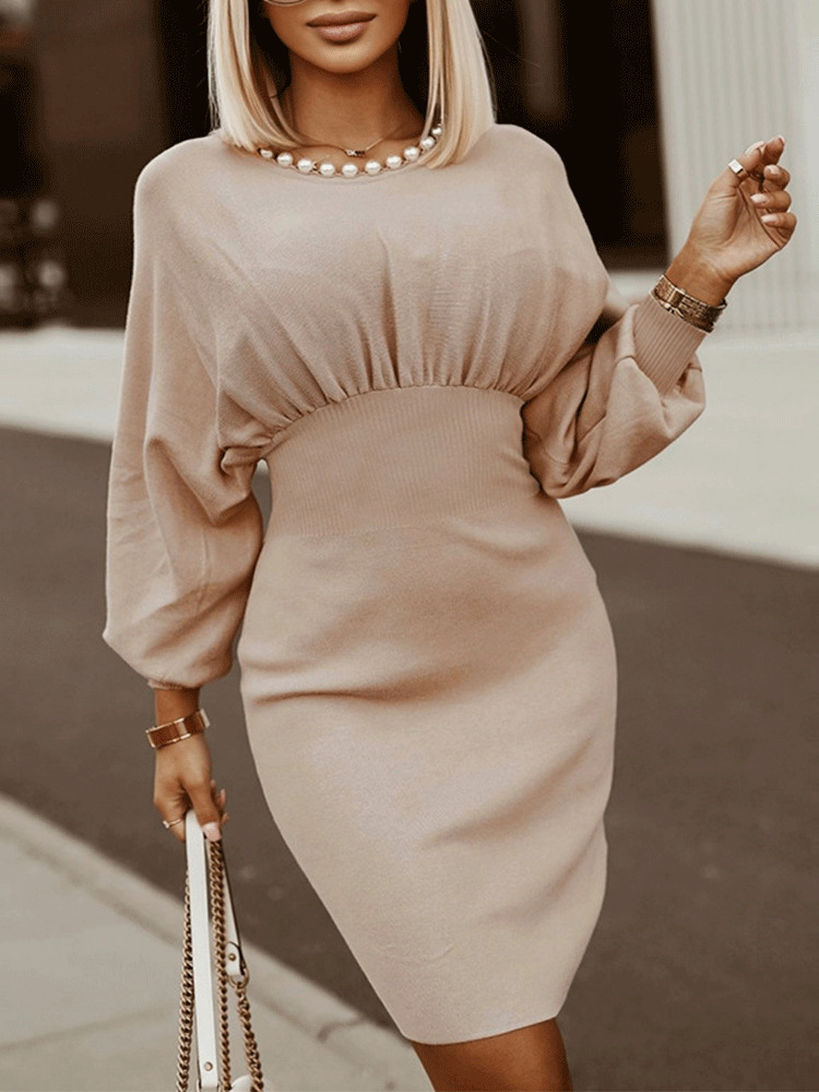 Close-up of the gathered neckline and pearl embellishment on a beige knit dress