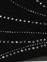 Close-up of black fabric with a mesh insert and decorative rhinestone detailing.
