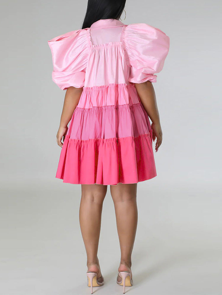 Back view of a woman in a pink tiered mini dress with puff sleeves