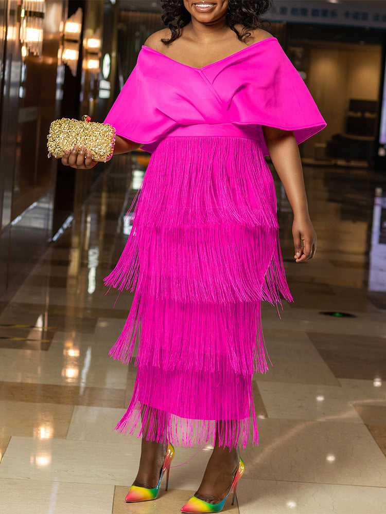 Woman wearing a vibrant pink off-the-shoulder dress with a tiered fringe skirt and a gold clutch.