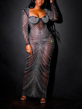 Woman wearing a long, sheer black dress with intricate silver bead embellishments.