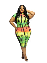 Plus-size woman in a vibrant tie-dye bodycon dress with short sleeves and a mock neckline, touching her hair.