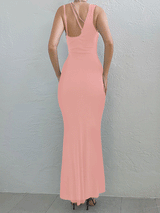 Back view of a woman in a light pink one-shoulder maxi dress