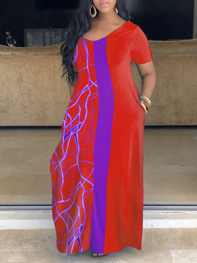 Woman wearing an orange and purple color block maxi dress with an abstract graphic print.