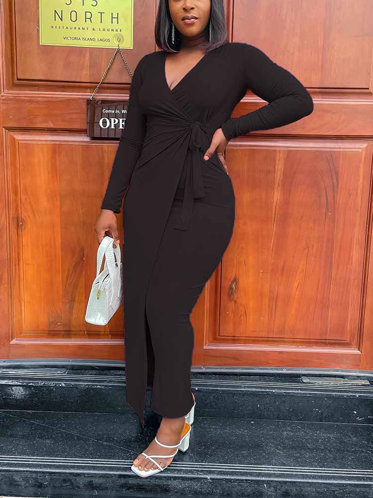woman wearing a long-sleeved black wrap dress with a tie waist and side slit