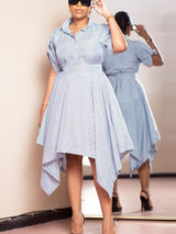 Woman adjusting her sunglasses while wearing a blue and white striped shirt dress.