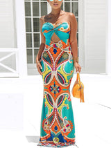 Full-body shot of a woman in a colorful printed strapless maxi dress