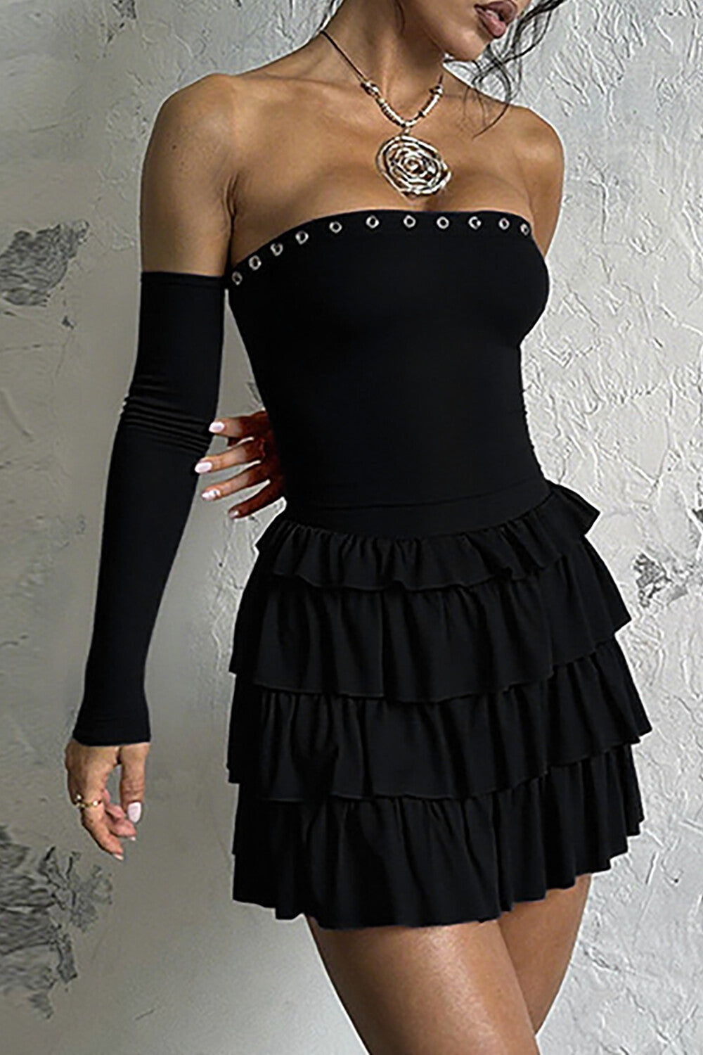 Close-up of the black off-the-shoulder dress, showing the eyelet detailing.