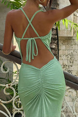 Close-up rear view of a light green maxi dress showing the criss-cross back straps and ruched skirt.