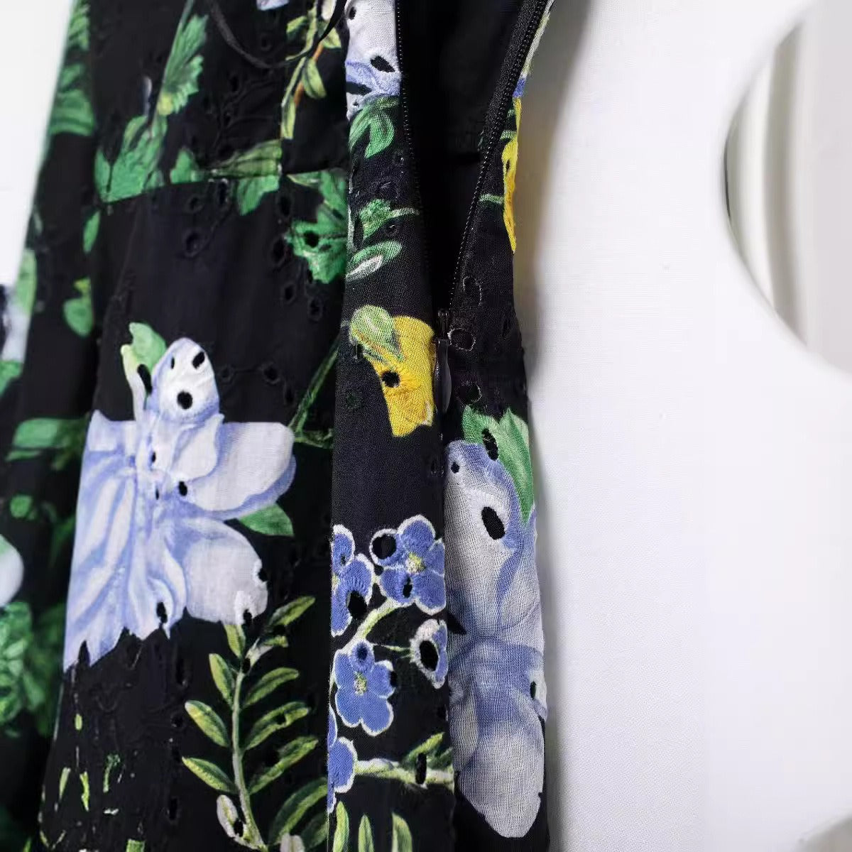 Close-up of the side zipper and fabric detail on a black floral print midi dress