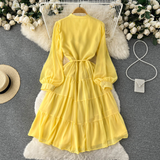 A woman wearing a chic pleated maxi dress with a tiered skirt and puff sleeves. - View 6 | Lwiis