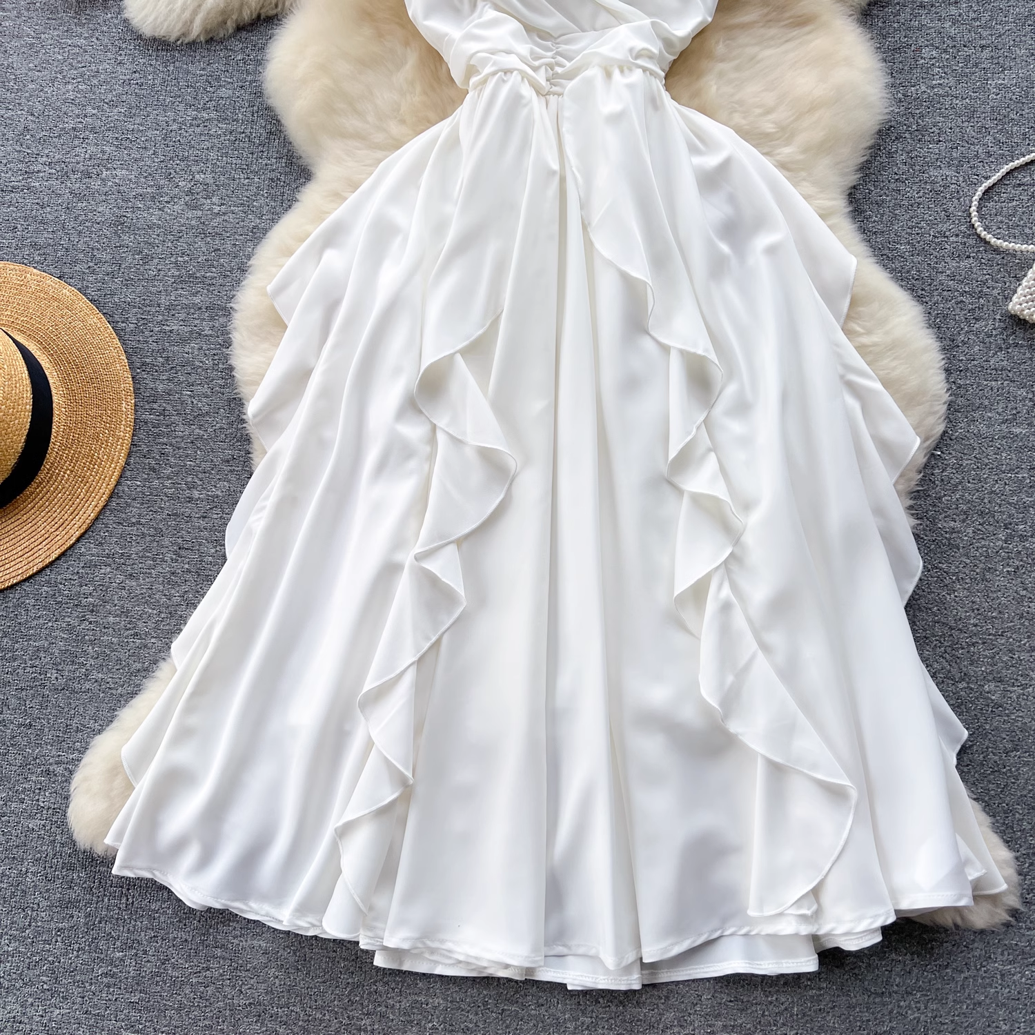 Full view of the ruffled skirt on a white satin cami dress.