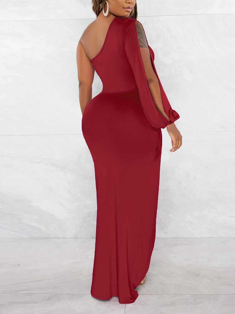 Woman wearing a long, black, one-shoulder dress with a high slit and a long sleeve on one side.