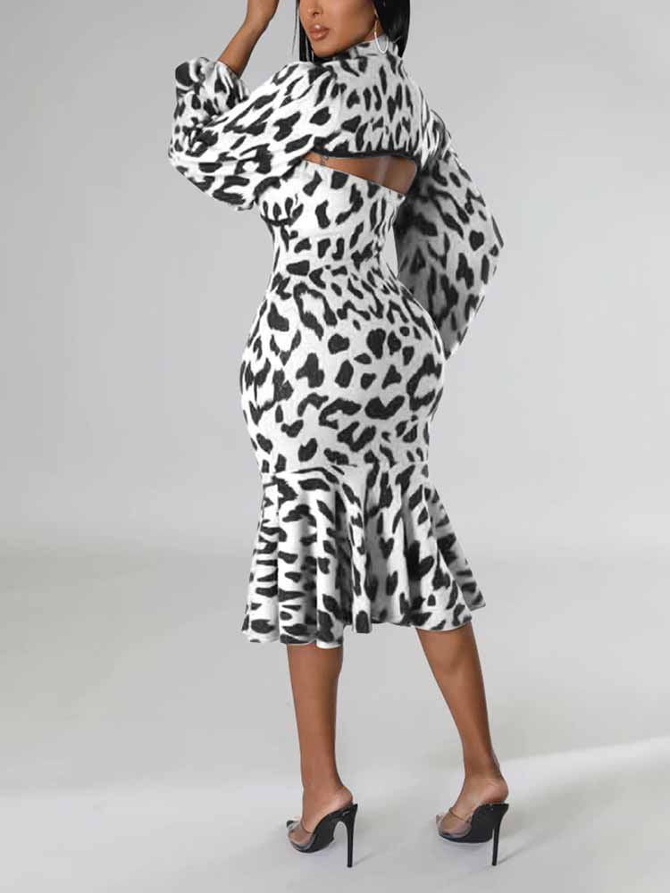 Back view of a woman wearing a black and white leopard print knit dress with a high neck, cut-out detail, long puff sleeves, and a mermaid hemline.