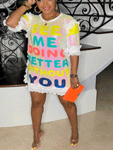 Woman wearing a white t-shirt dress with colorful sequin letters spelling "See Me Doing Better Without You" and ruffled trim.