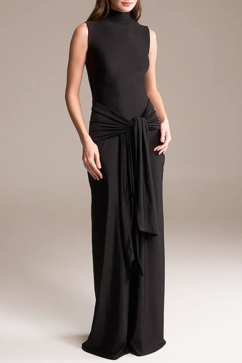 woman wearing a black sleeveless mock neck floor-length gown with a draped waist