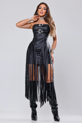 Woman wearing a black strapless faux leather dress with fringe detailing and knee-high boots, front view.