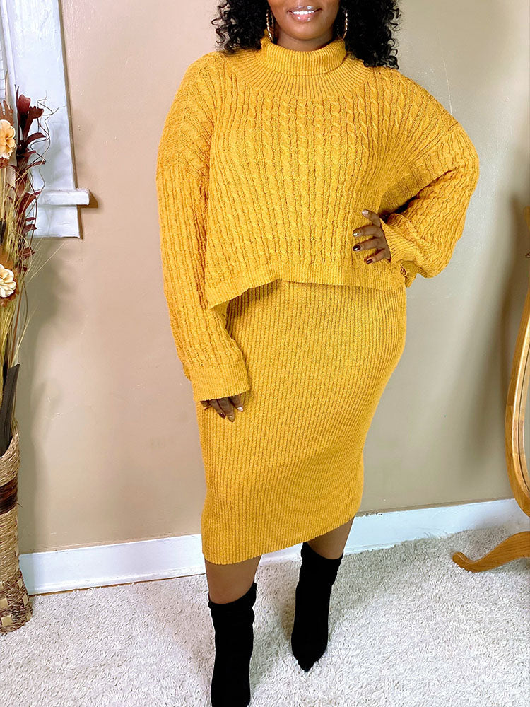 Woman wearing a yellow cable knit cropped sweater and a matching ribbed knit midi skirt, paired with black ankle boots.
