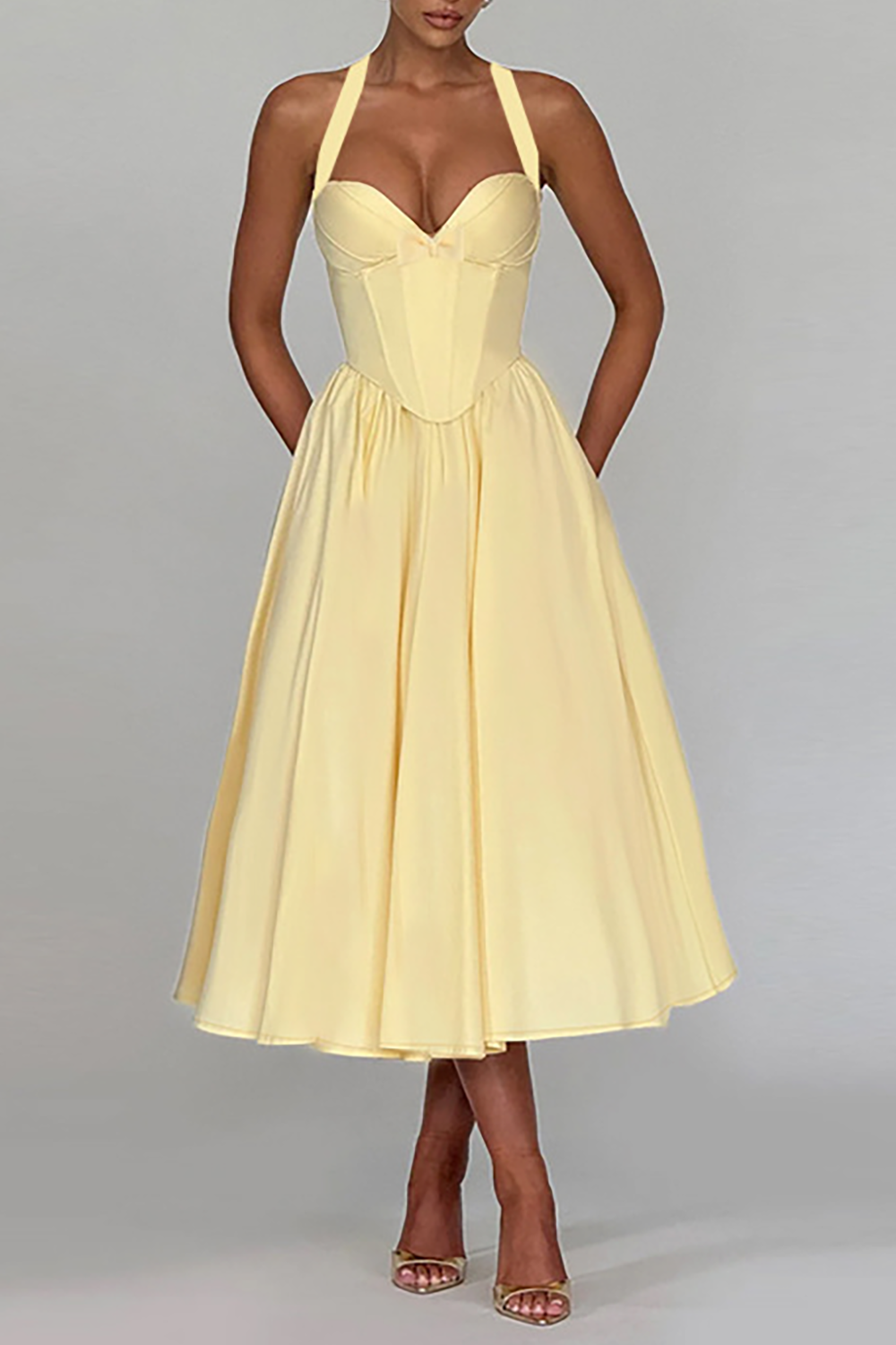 Full-length view of a pale yellow midi dress with a halter neckline and corset bodice.