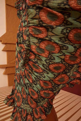 Detail of the ruffled sleeve and V-neckline of the metallic jacquard dress.