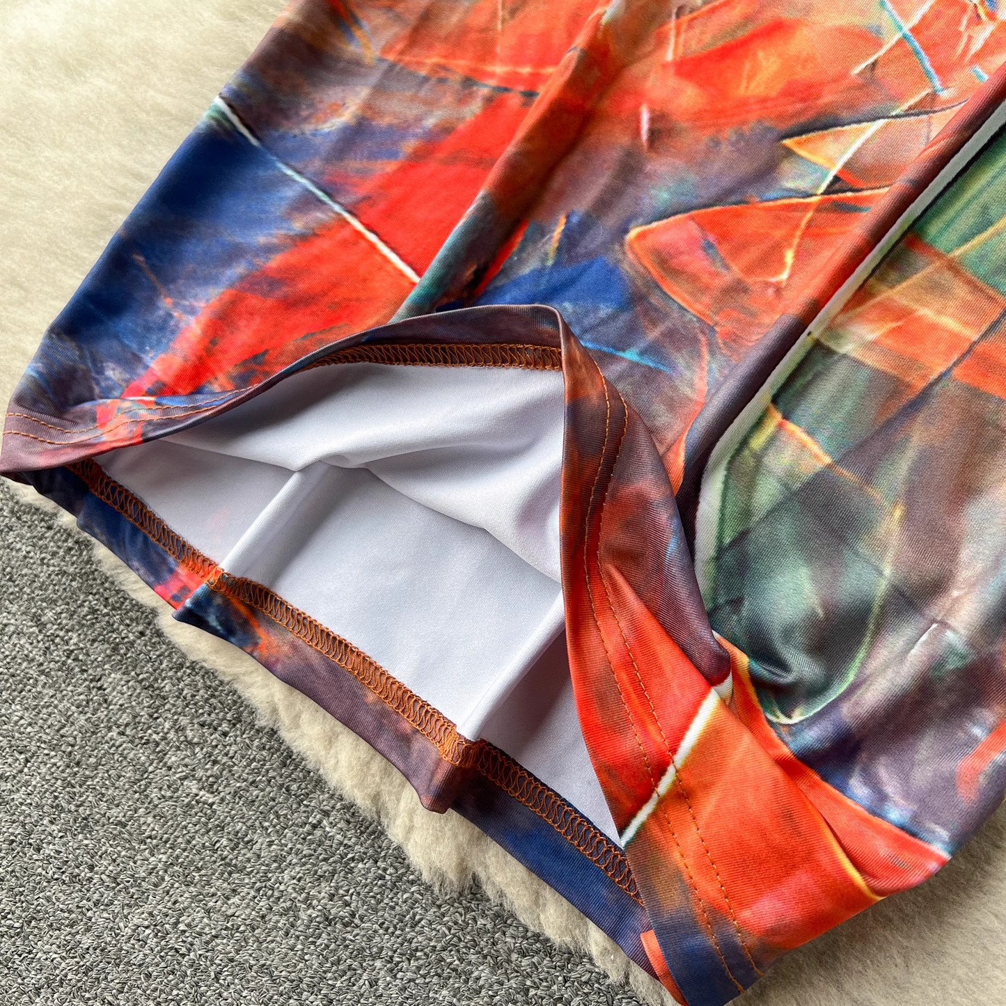 Detail shot of the hem of the long-sleeved abstract print maxi dress, showing the stitching and lining.