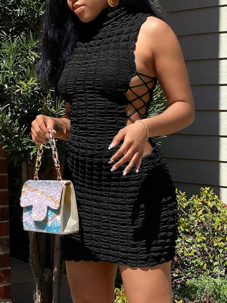 Woman wearing a black sleeveless textured knit bodycon dress with lace-up sides and a turtleneck
